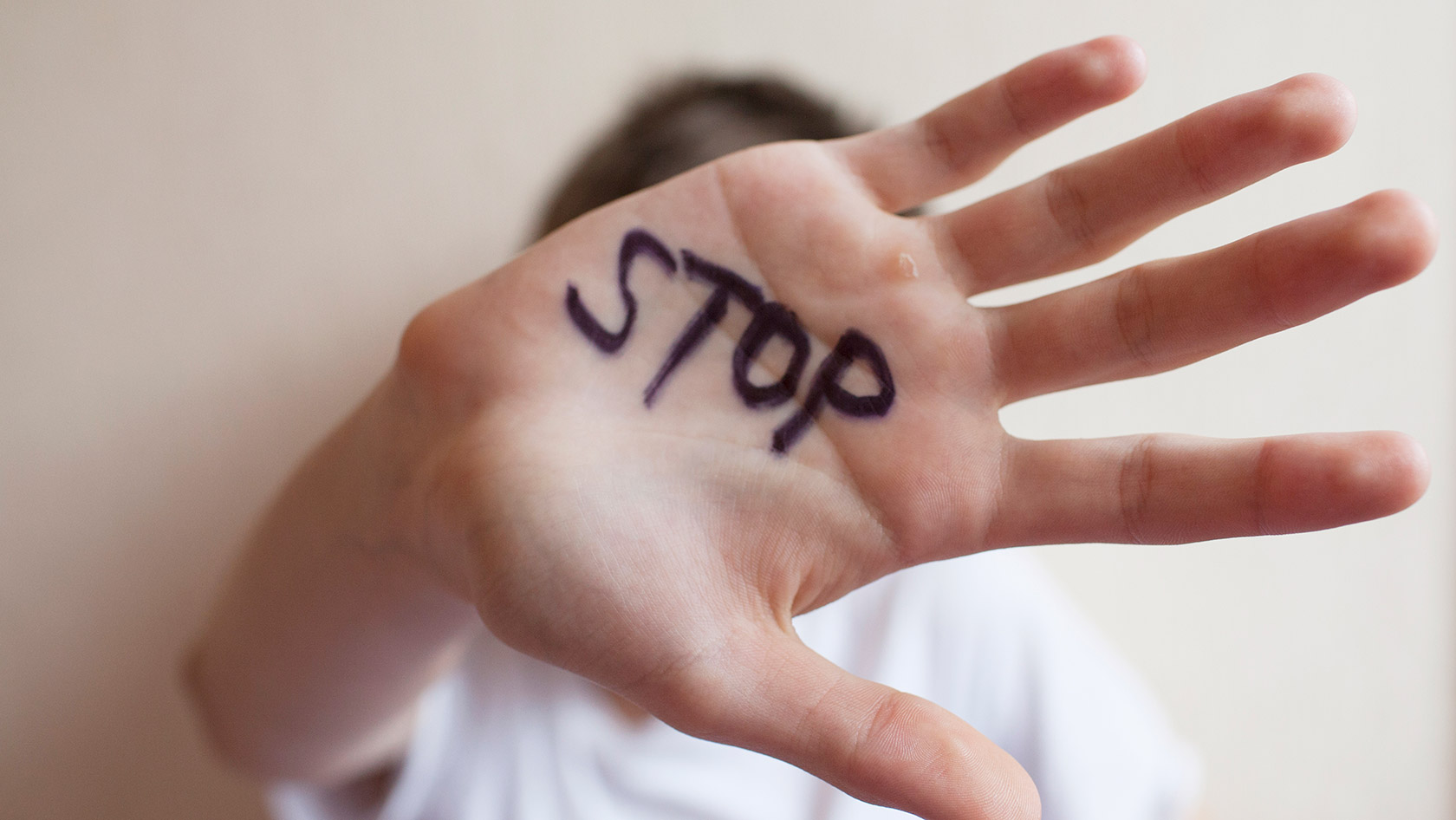 Hand with "Stop" in front of face