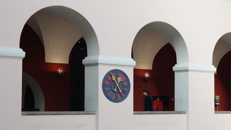 A clock on the wall of the Lichthof in the U Z H main building