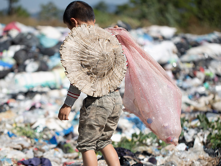 Kind wühlt auf Müllhaufen