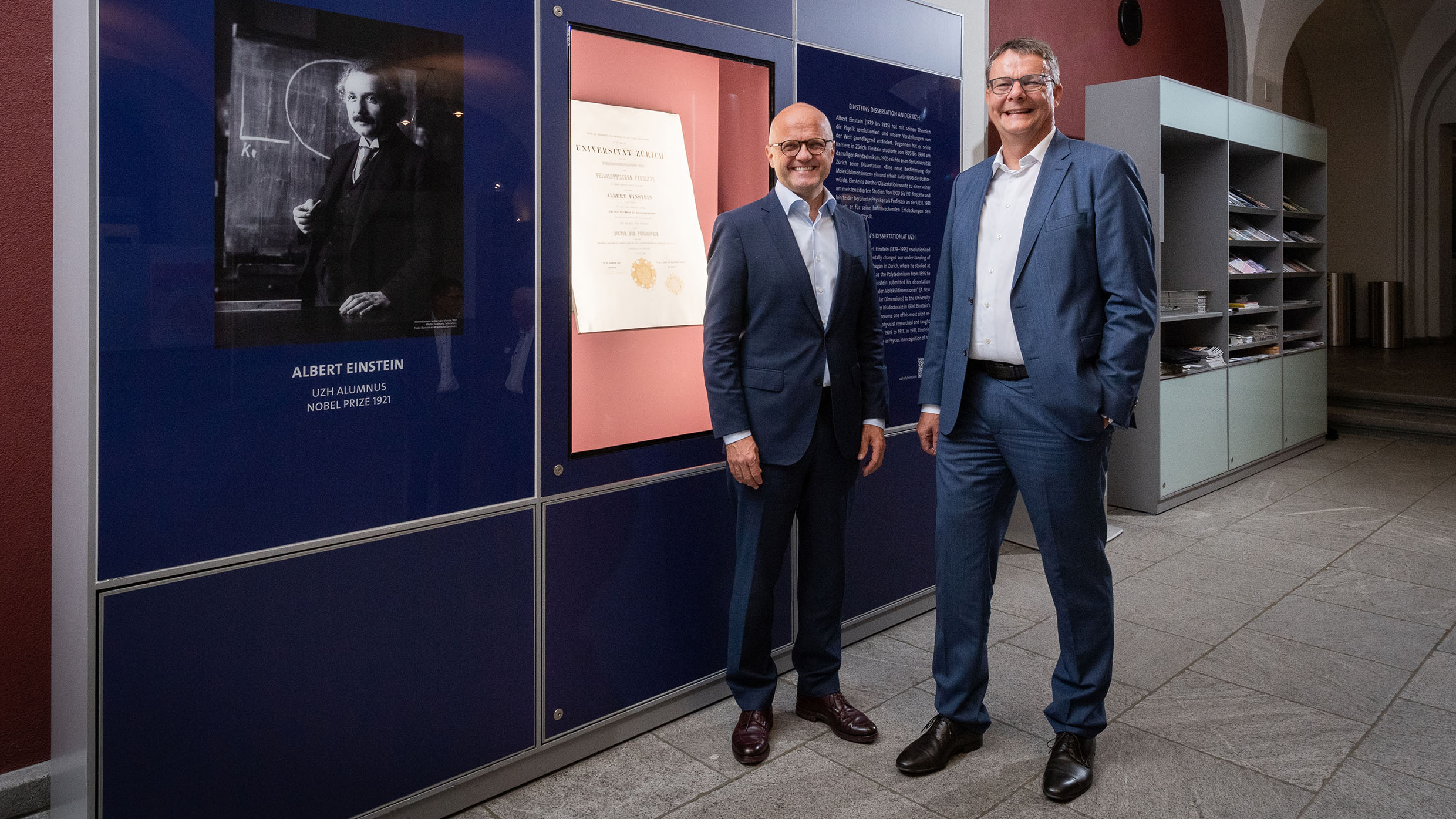 President Michael Schaepman and Vidar Helgesen, Executive Director of the Nobel Foundation, in front of Albert Einstein's original UZH doctoral certificate. 1 September 2022 (Photo: Frank Brüderli)