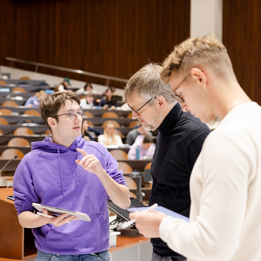 Dozent mit Studierenden im Hörsaal