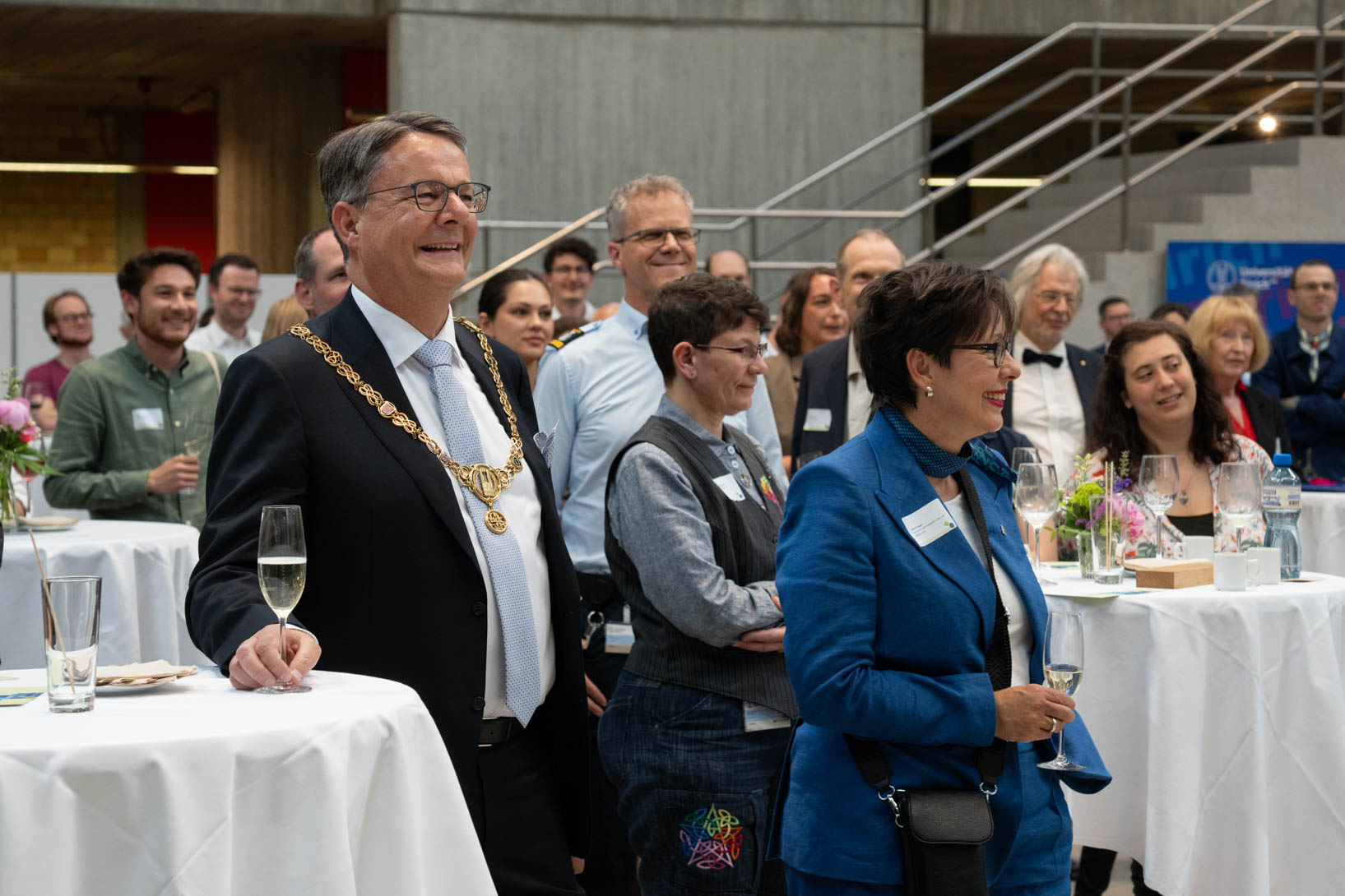 Rektor Michael Schaepman und Vize-Rektorin Gabriele Siegert hören gemeinsam mit den anwesenden Gästen der Tischrede zu.